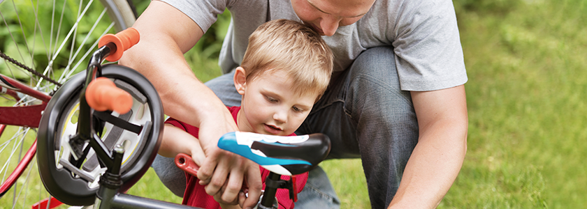 Father and young son working on fixing a bike together