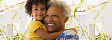 Smiling grandmother and granddaughter hugging