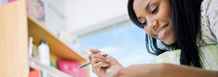 College-age student working on her homework in her dorm room