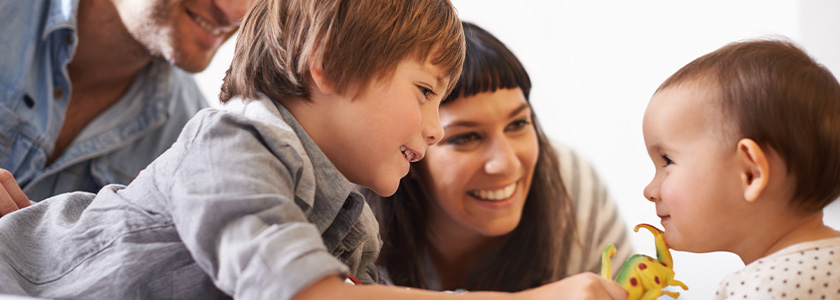 Older brother and mother play with younger sibling