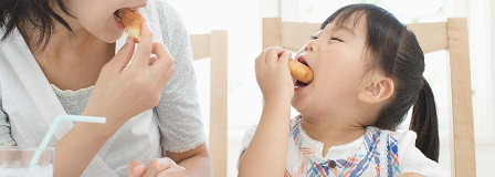 Mom and daughter share a donut