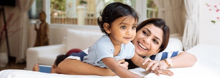 Mom smiles at her daughter who is looking out the window