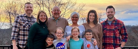 The Steger Family standing in front of sunset